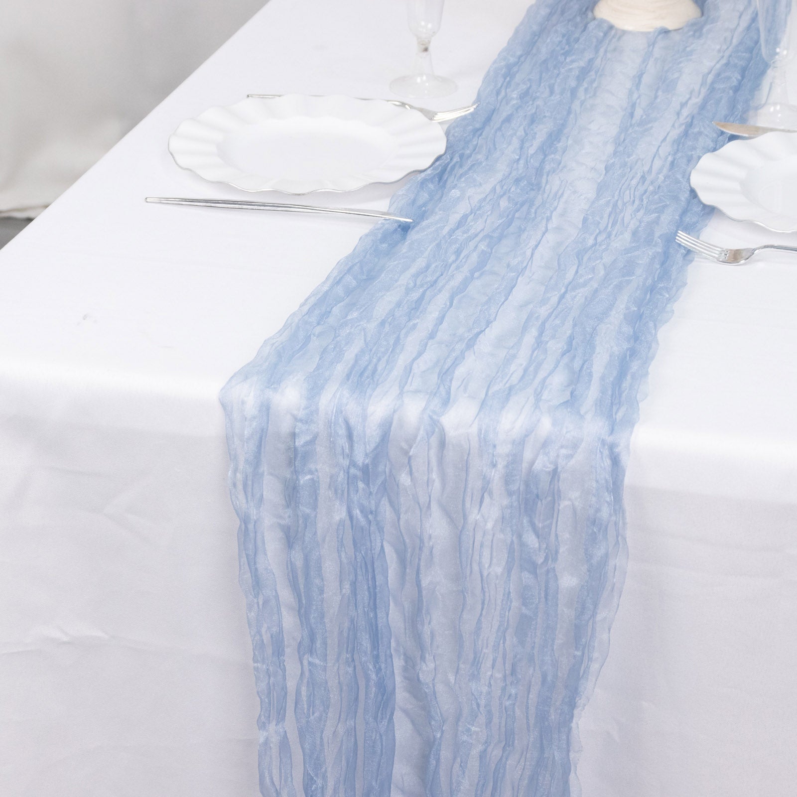 9ft Dusty Blue Sheer Crinkled Organza Table Runner on a white table.