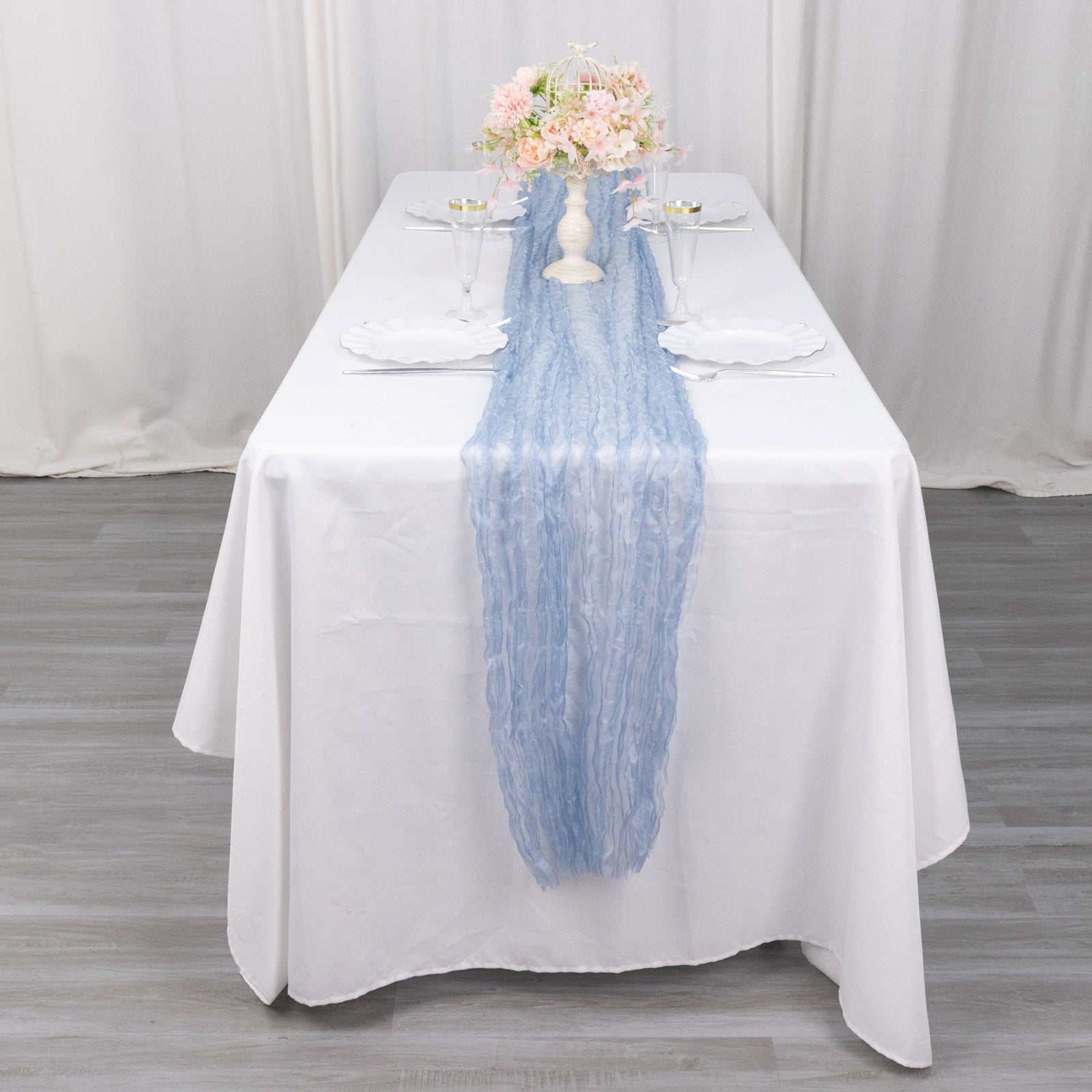 9ft Dusty Blue Sheer Crinkled Organza Table Runner on a white table.