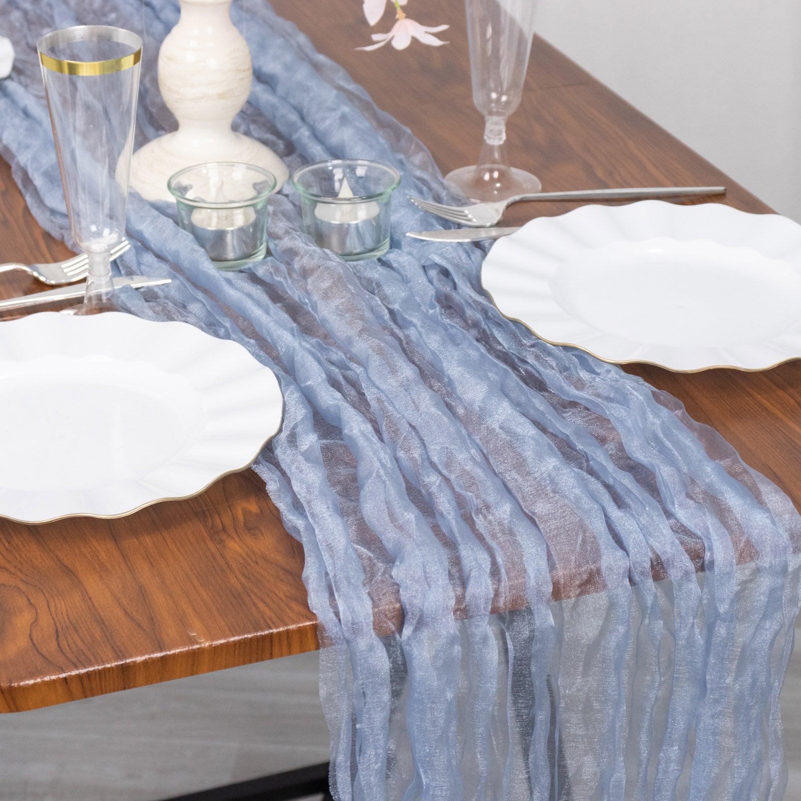9ft Dusty Blue Sheer Crinkled Organza Table Runner on a wooden table.