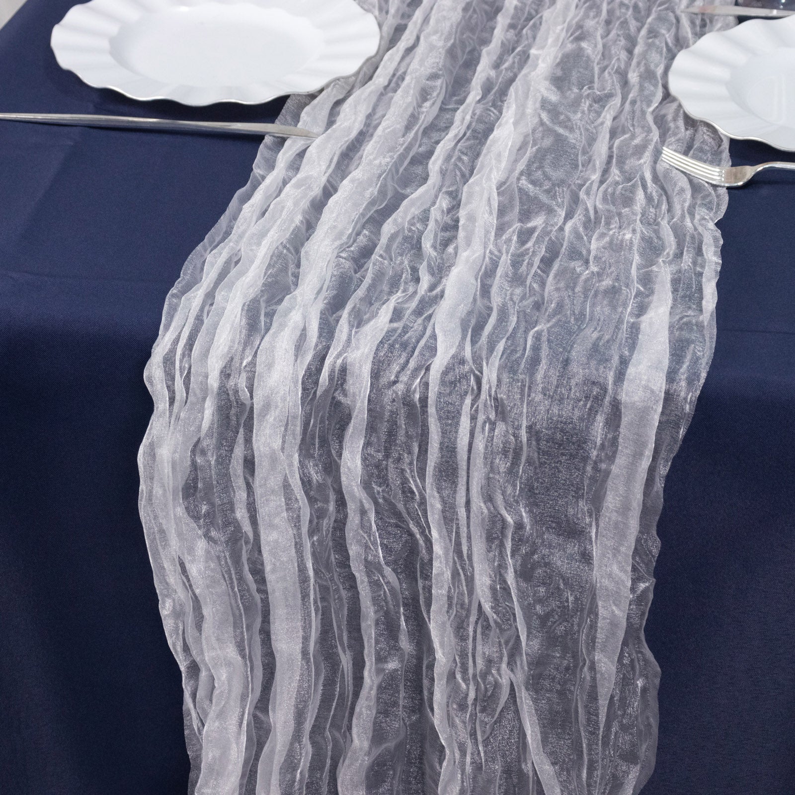 9ft white sheer crinkled organza table runner on a navy blue table.