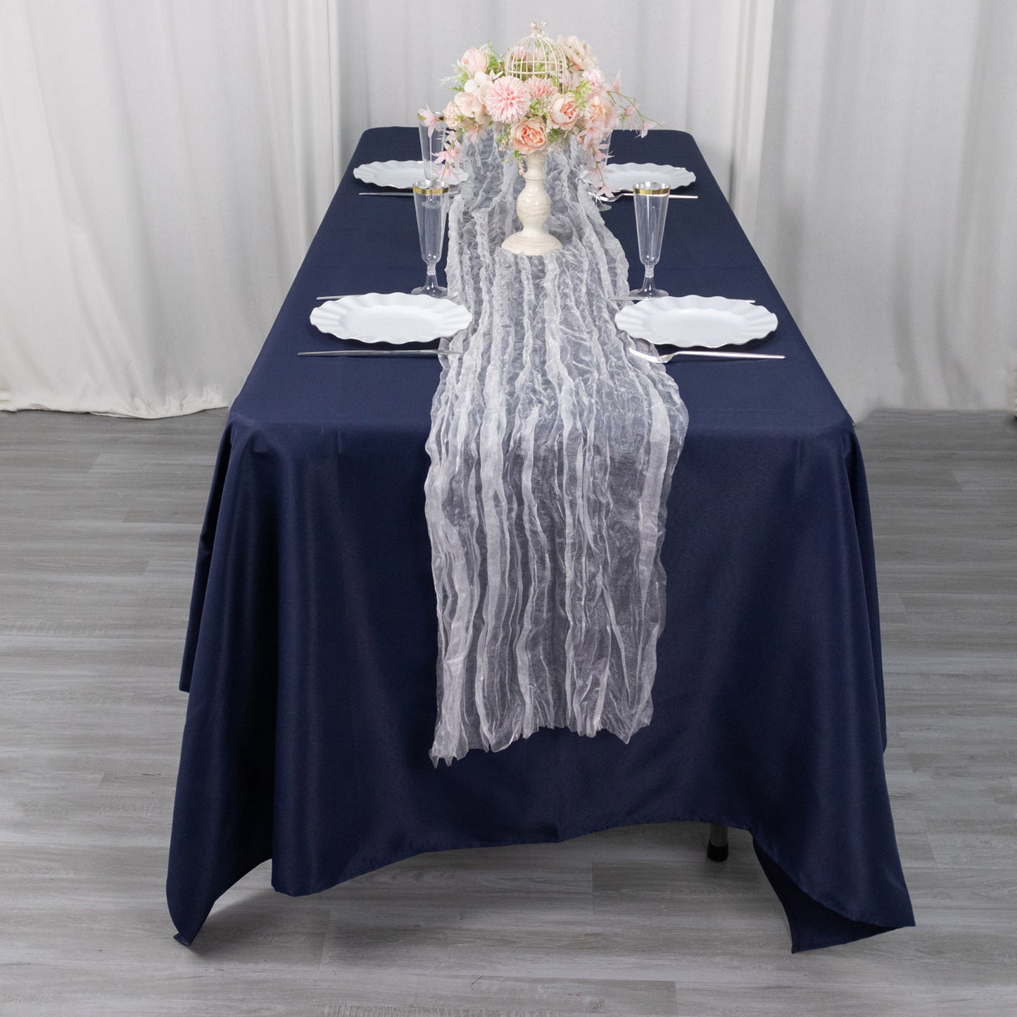 White sheer crinkled organza table runner on a navy blue table.