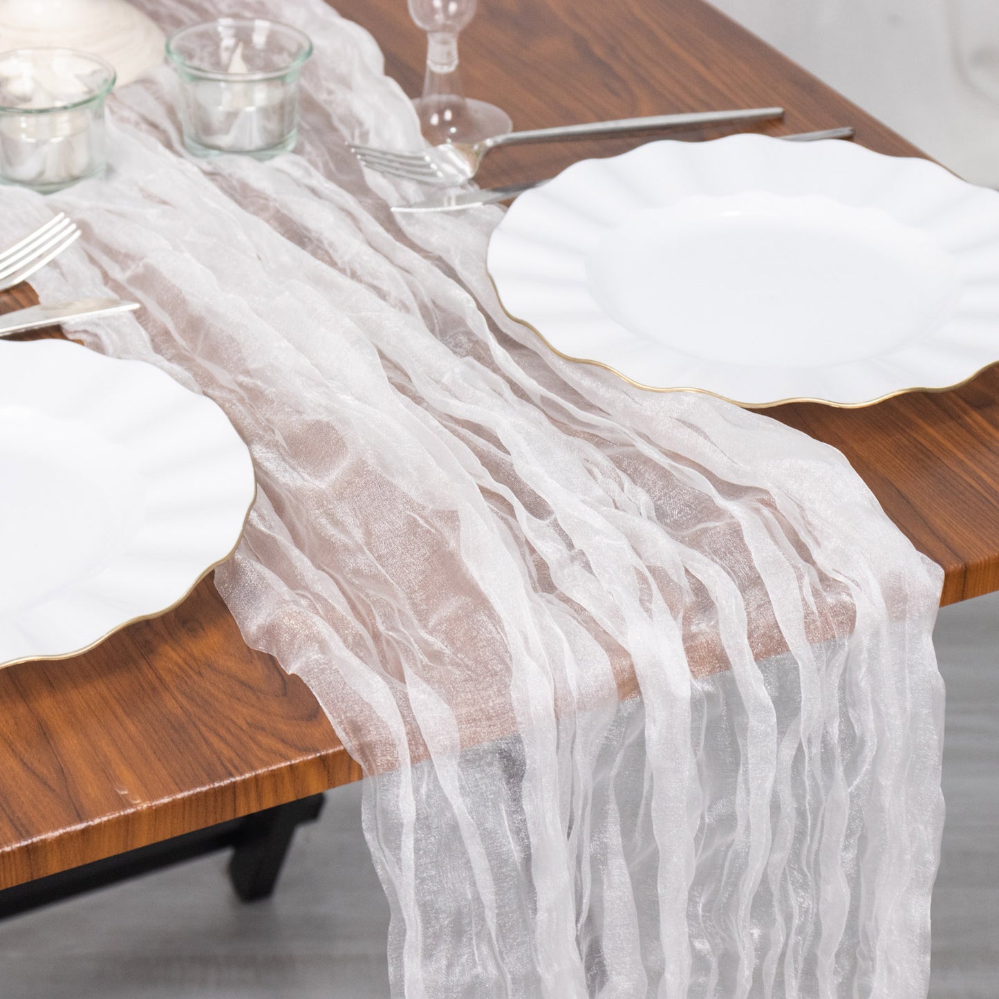 9ft white sheer crinkled organza table runner on a wooden table.