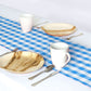 Blue and white plaid table runner on a dining table setting.
