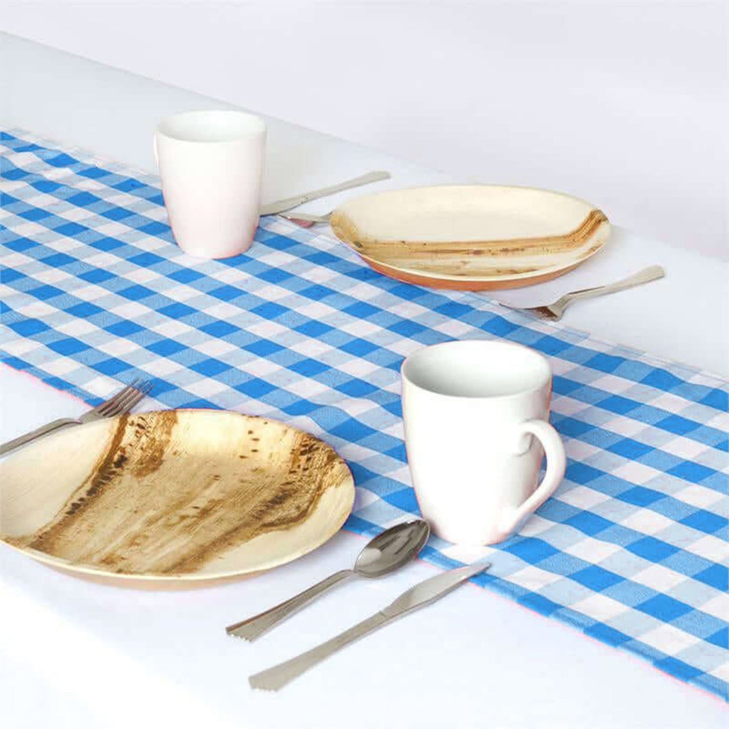 Blue and white plaid table runner on a dining table setting.