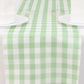 White sage green checkered table runner on a dining table.