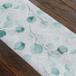 White disposable table runner with green eucalyptus leaves print.