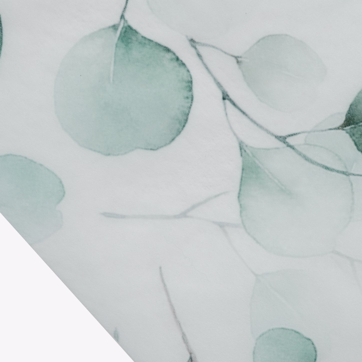 White table runner with green eucalyptus leaves print for dining decor.