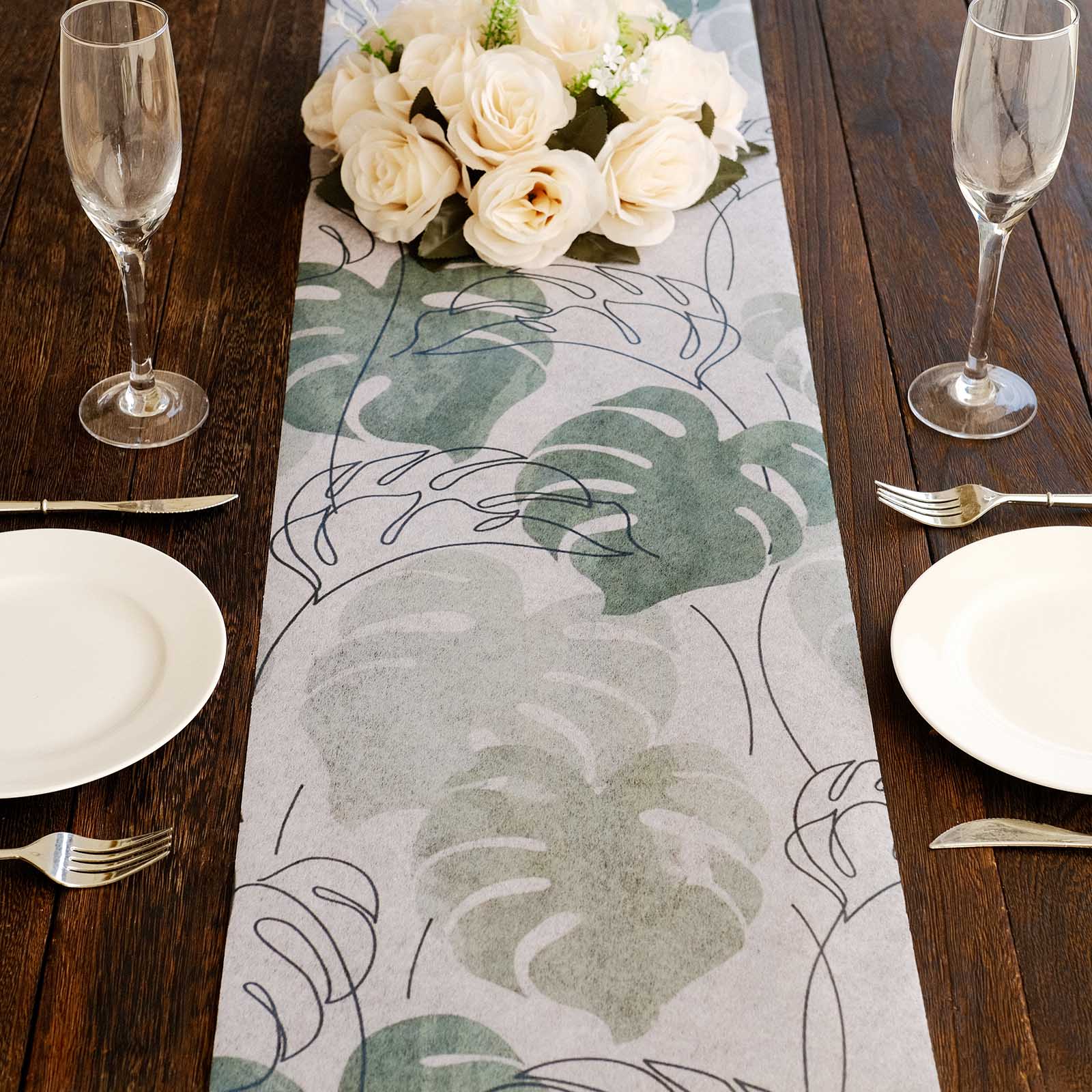 White table runner with green monstera palm leaves print for stylish dining decor.