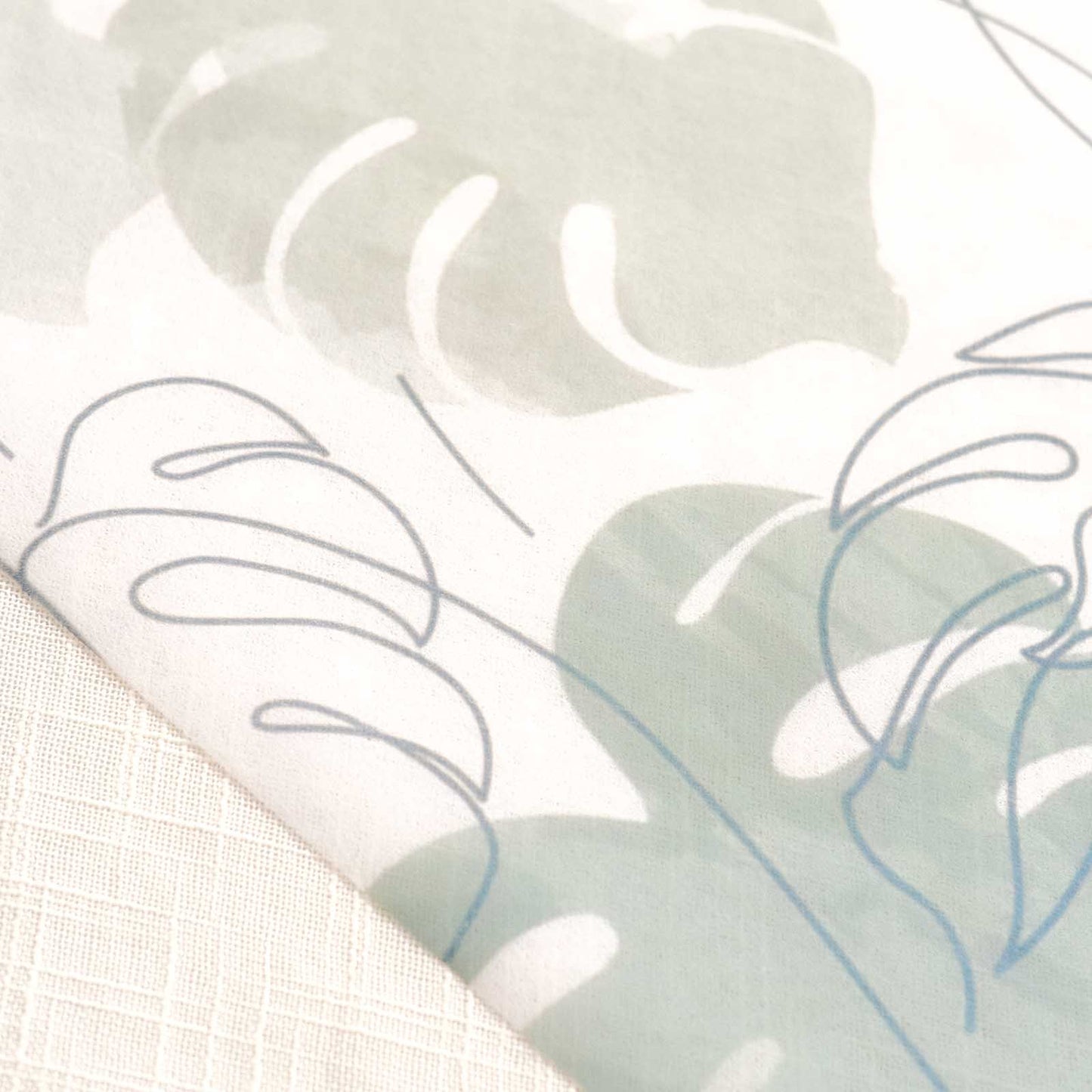 White table runner with green monstera palm leaves print, stylish dining decor.