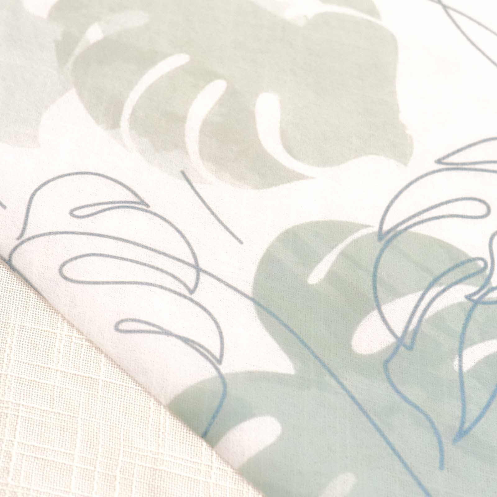 White table runner with green monstera palm leaves print, stylish dining decor.