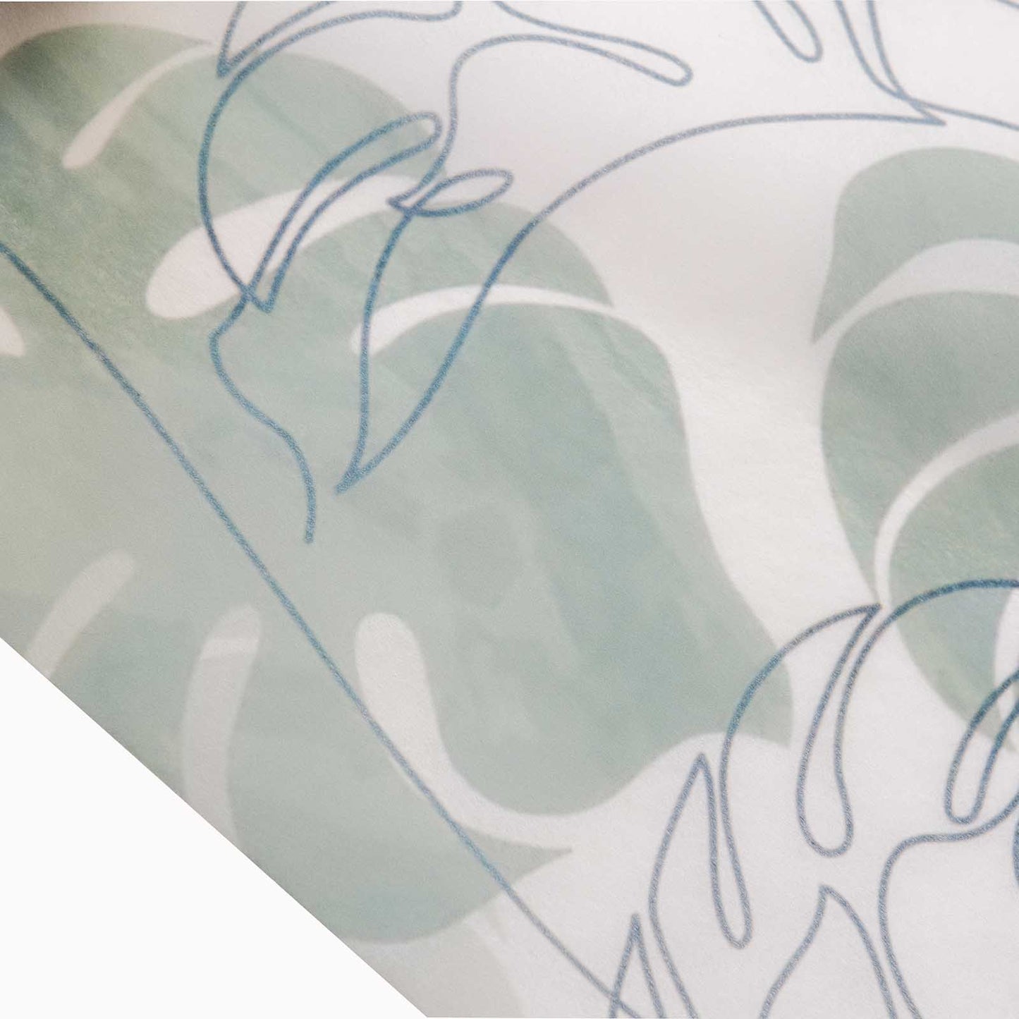 White disposable table runner with green monstera palm leaves print.