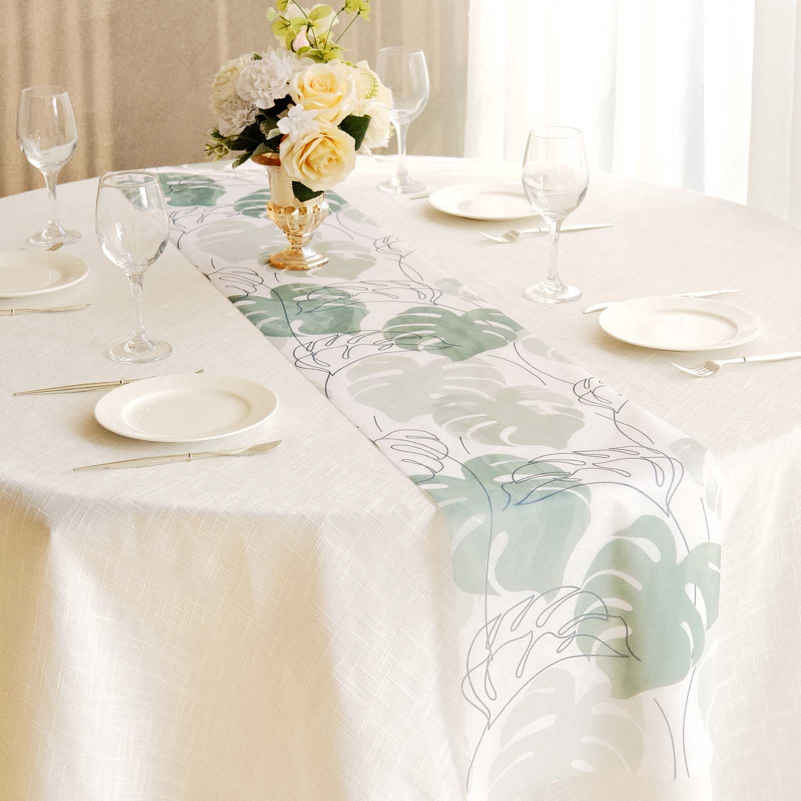 White disposable table runner with green monstera palm leaves print.