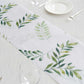 White disposable table runner with green olive leaves print for stylish dining decor.