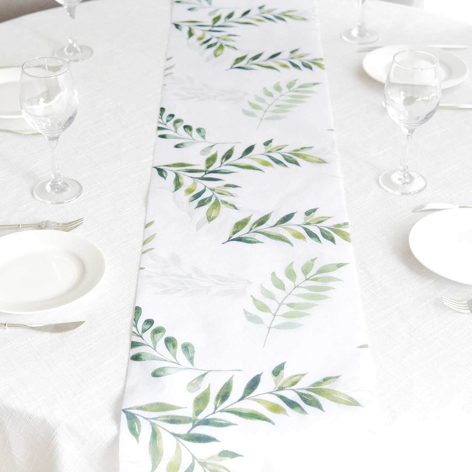 White table runner with green olive leaves print on a dining table setting.