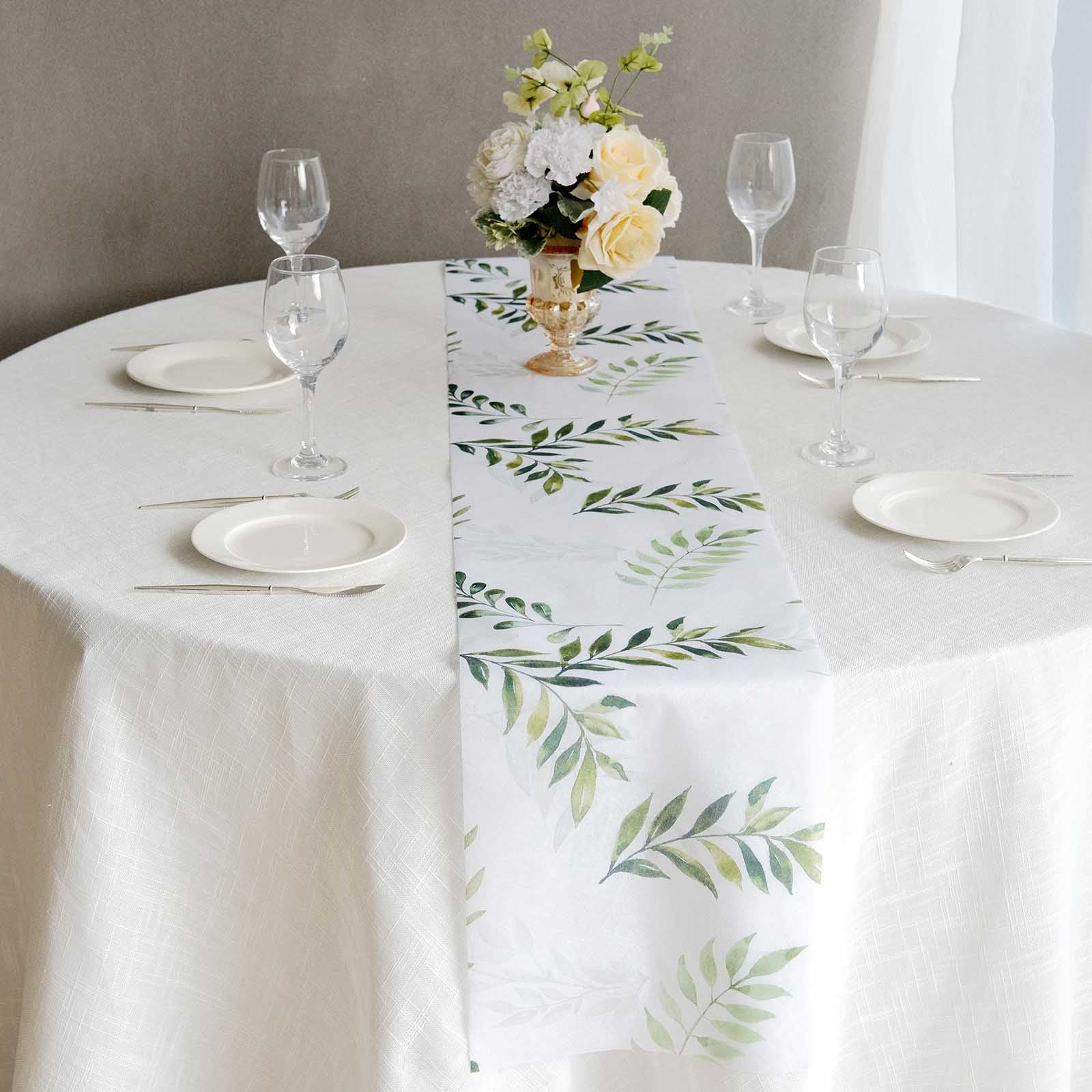 White table runner with green olive leaves print on a dining table setting.