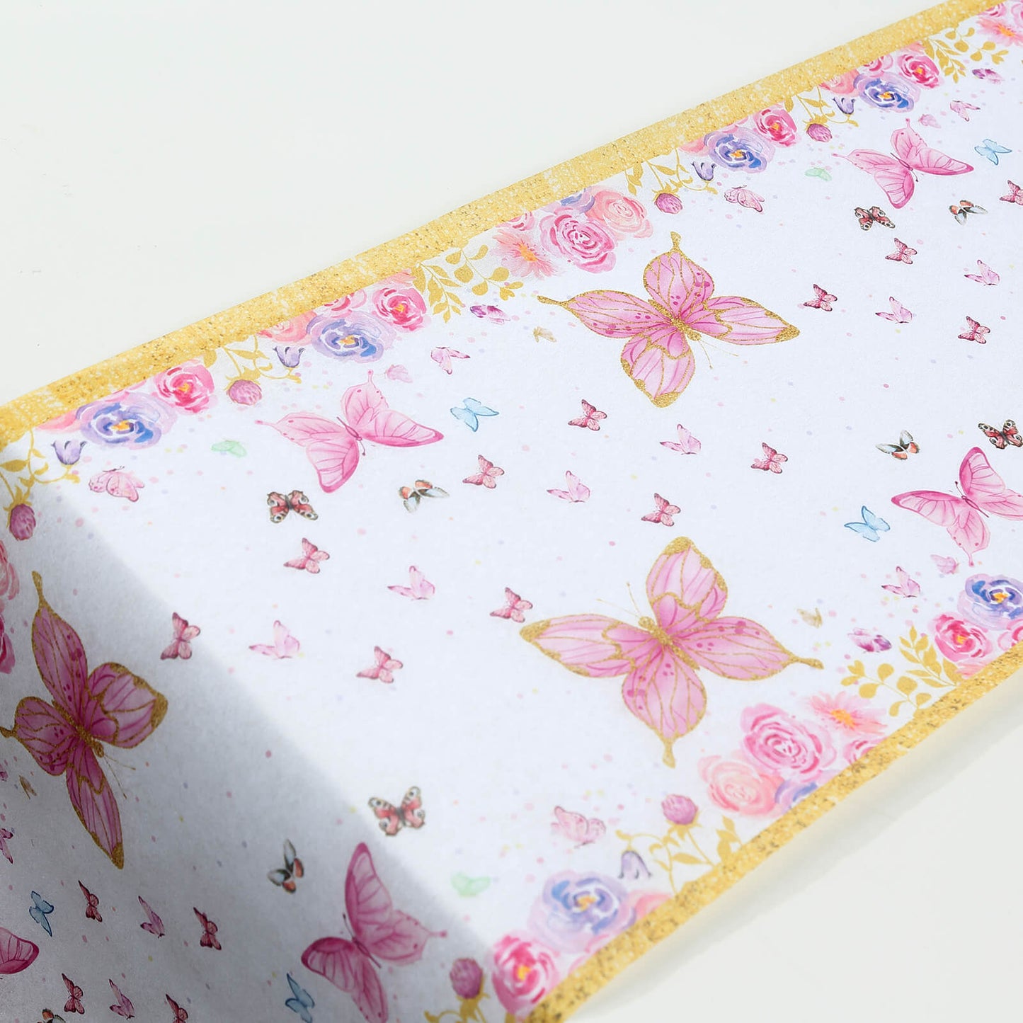 White table runner with pink butterflies and floral design.