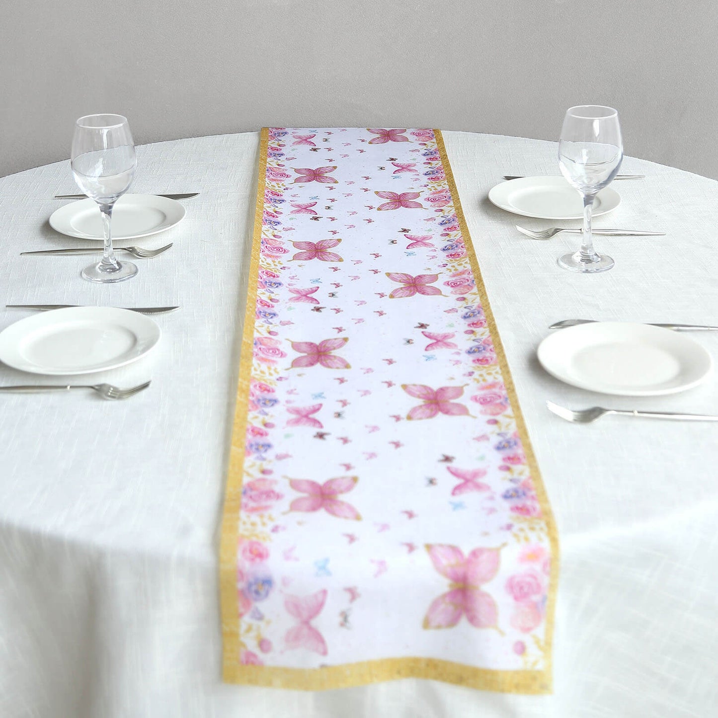 White table runner with pink butterflies on a dining table.