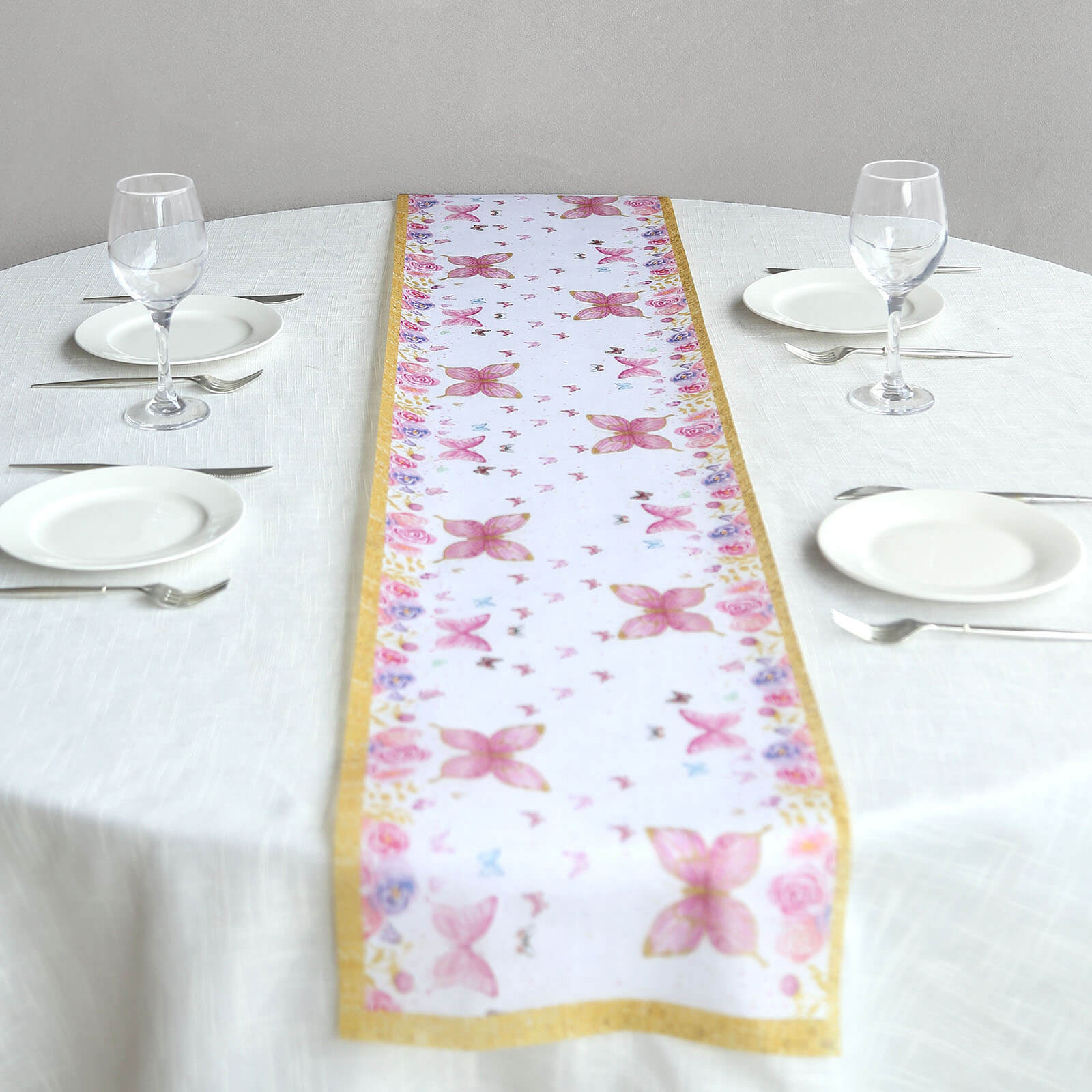 White table runner with pink butterflies on a dining table.