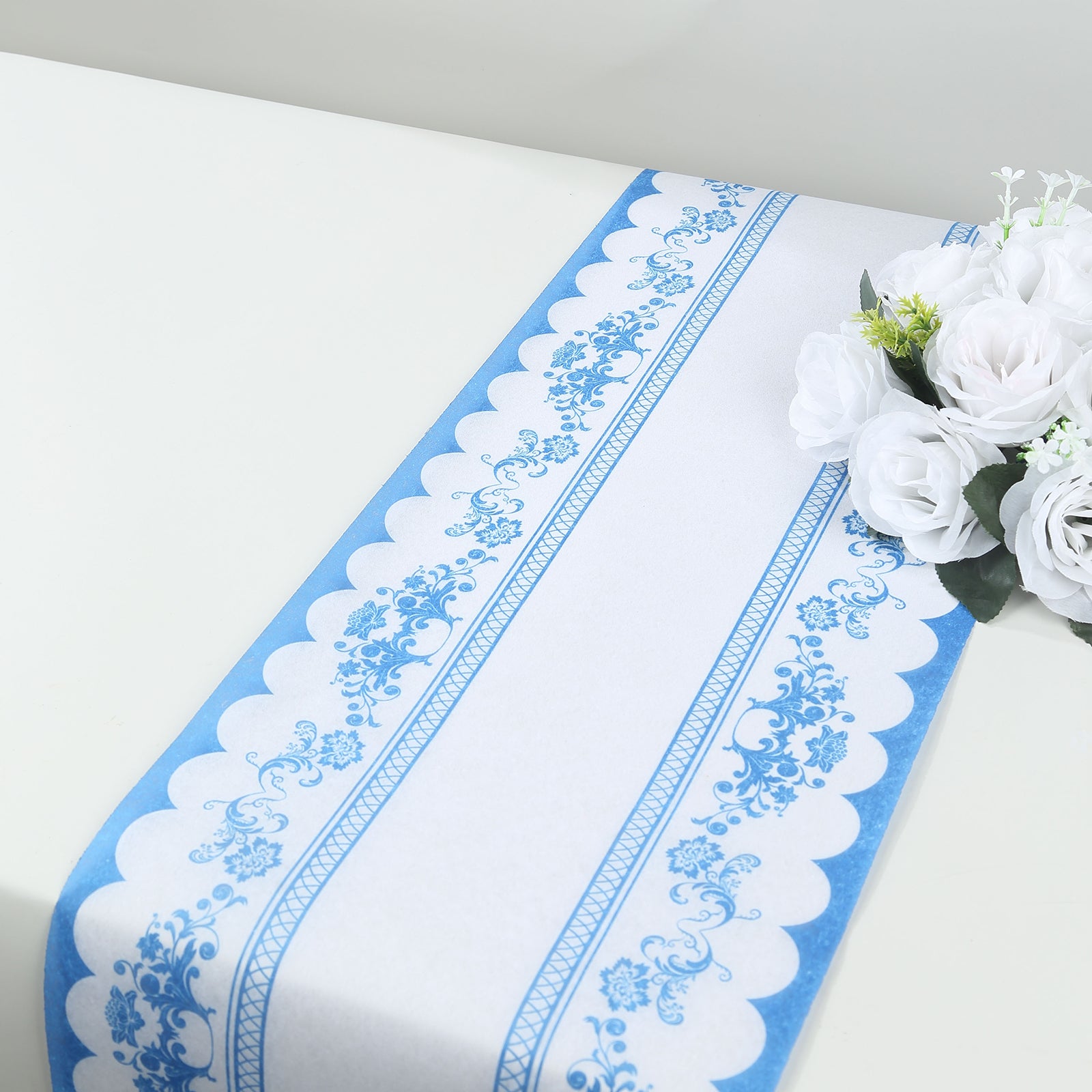 White and blue ornate floral disposable table runner on a light surface.
