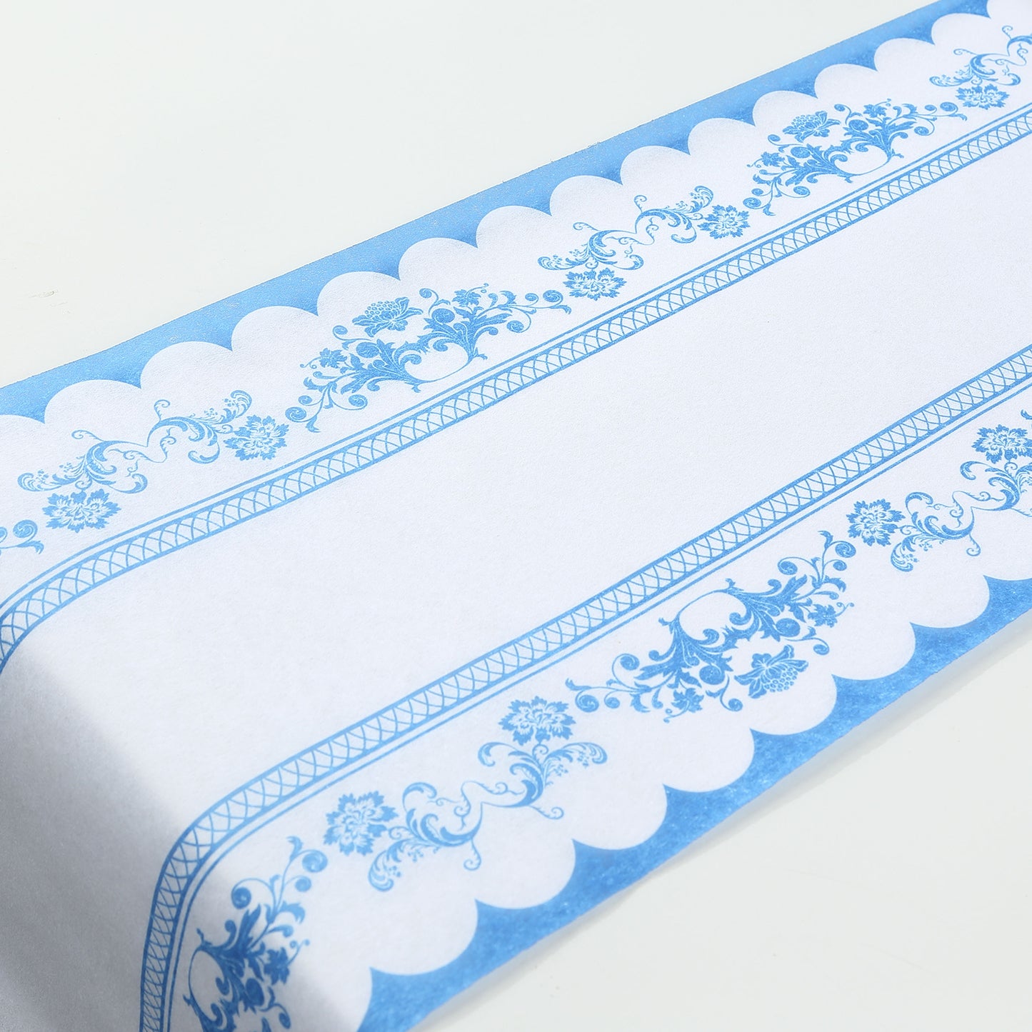 White table runner with blue ornate floral prints, perfect for dining decor.
