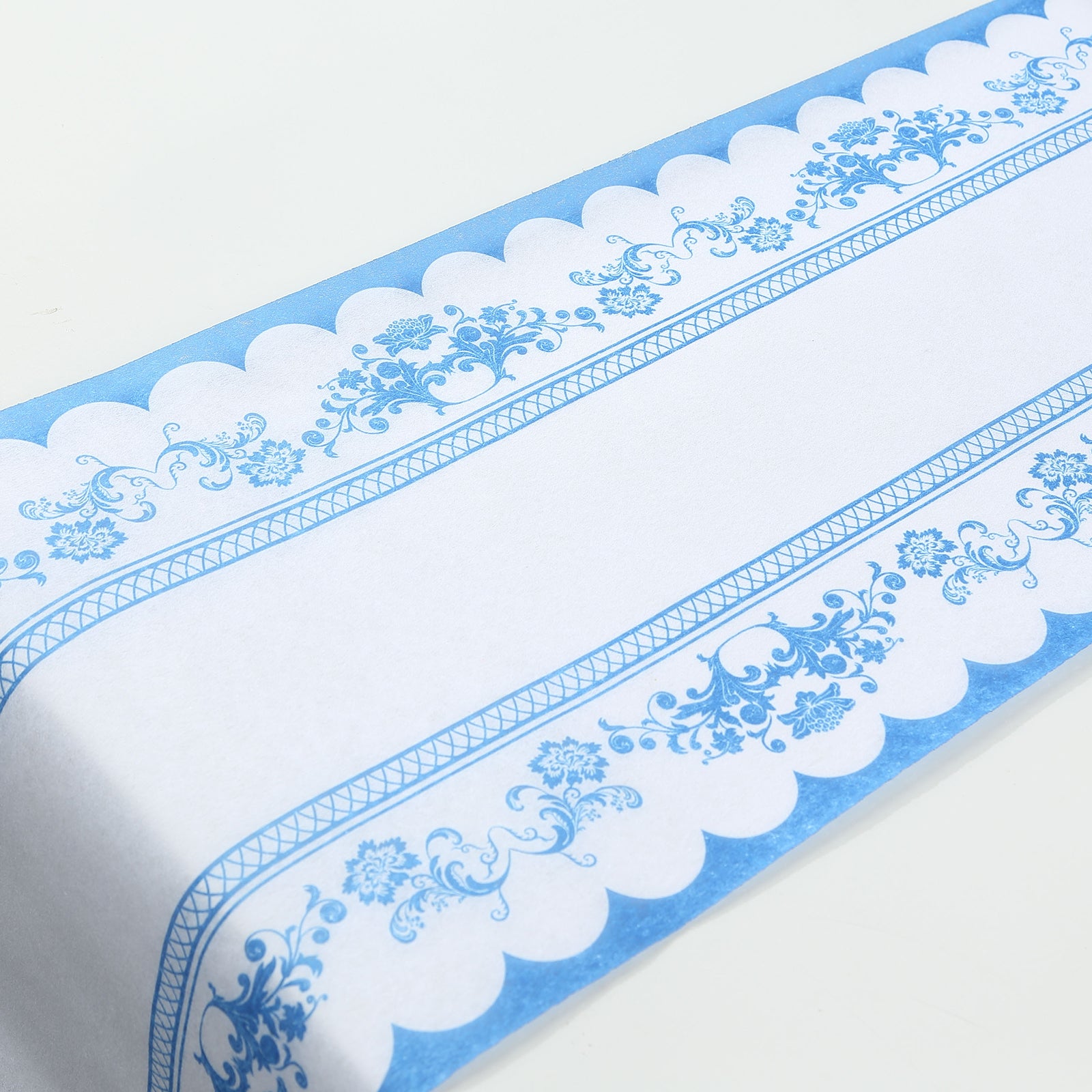 White table runner with blue ornate floral prints, perfect for dining decor.