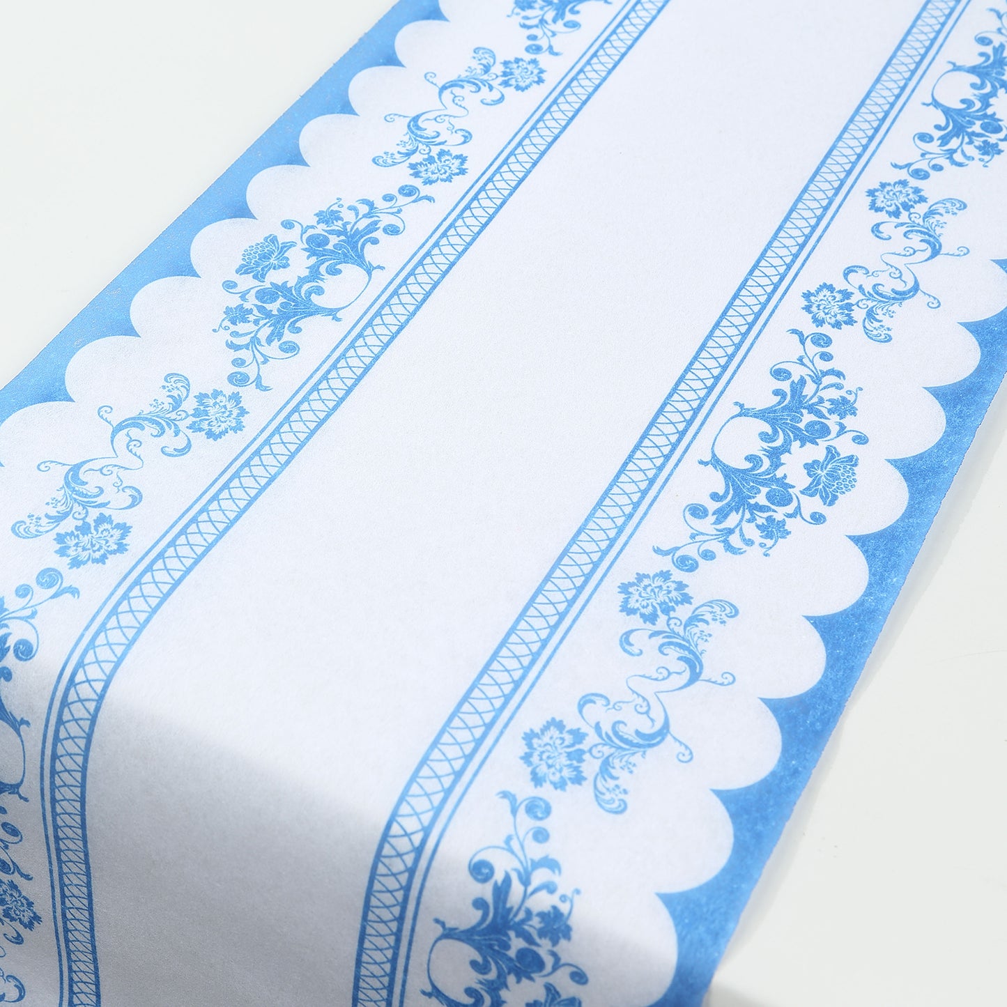 White table runner with blue ornate floral prints, perfect for dining decor.