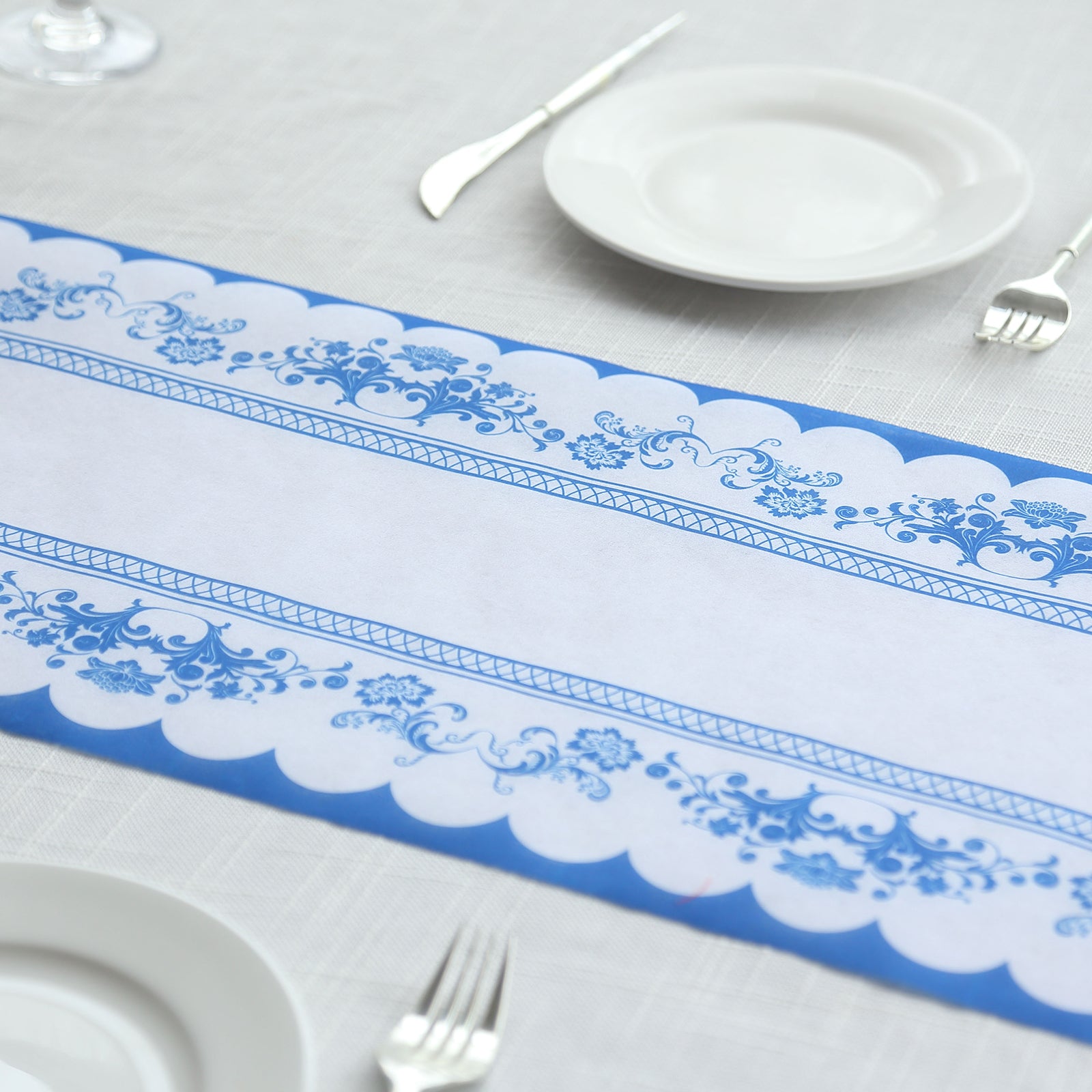 White table runner with blue ornate floral prints on a dining table.