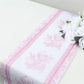 White with pink floral pattern disposable table runner on a dining table.