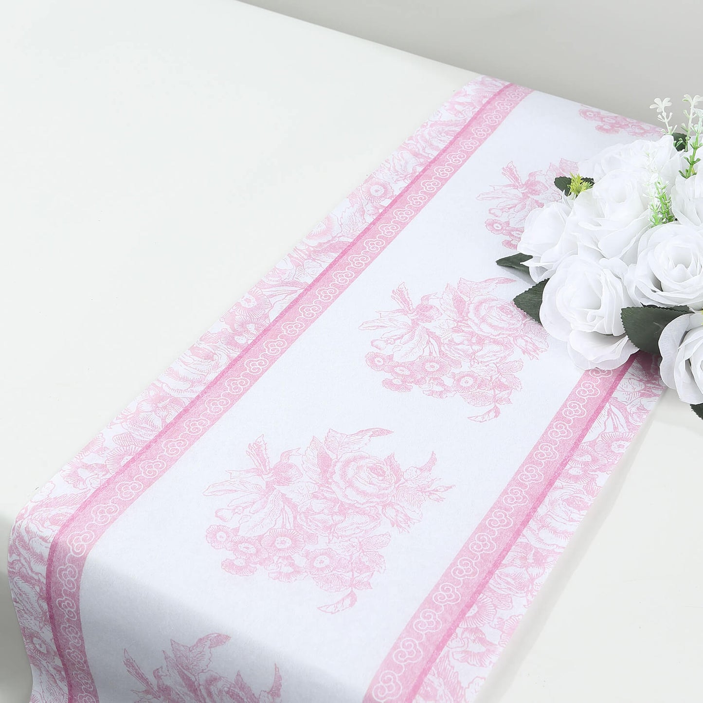 White with pink floral pattern disposable table runner on a dining table.