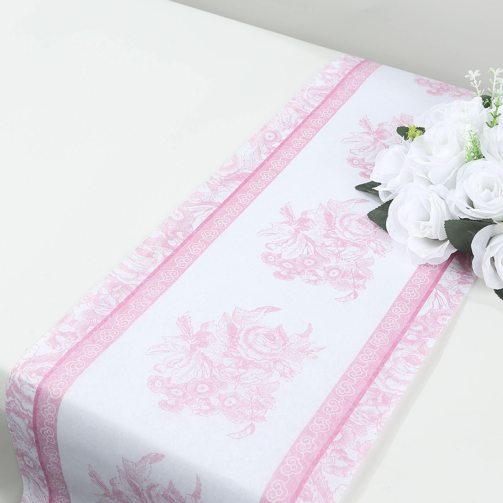 White with pink floral pattern disposable table runner on a dining table.