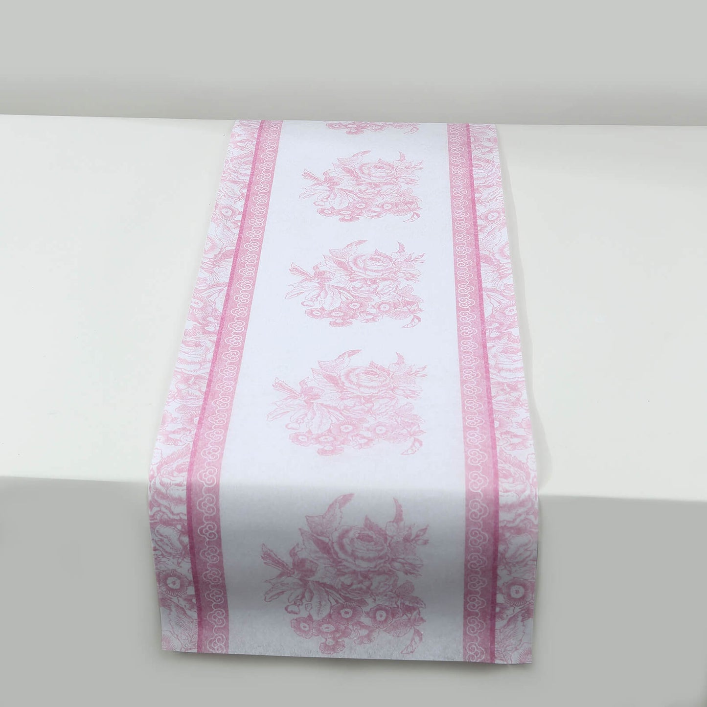 White and pink floral disposable table runner for stylish dining decor.