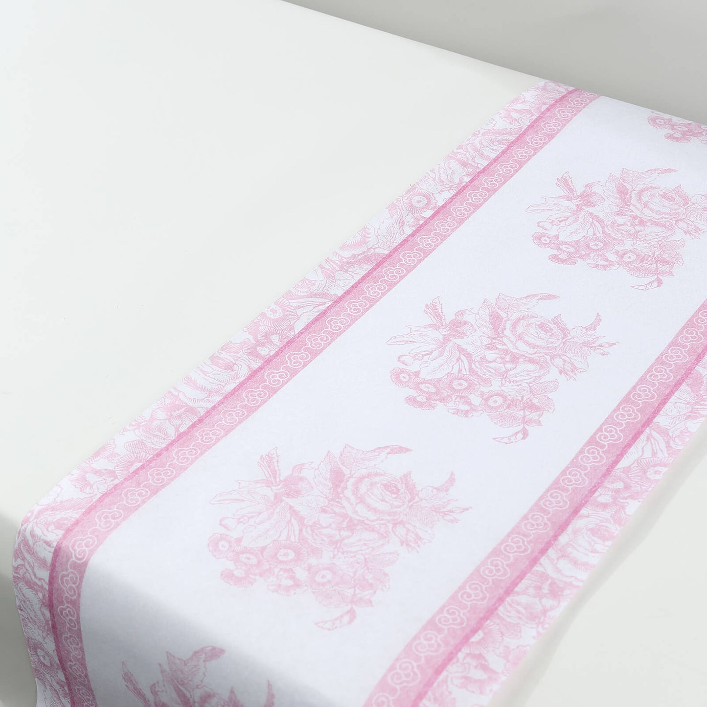 White and pink floral disposable table runner for stylish dining decor.