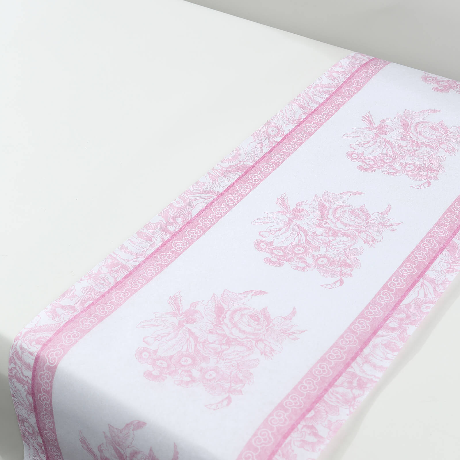 White and pink floral disposable table runner for stylish dining decor.