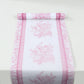 White table runner with pink floral pattern, stylish for dining decor.