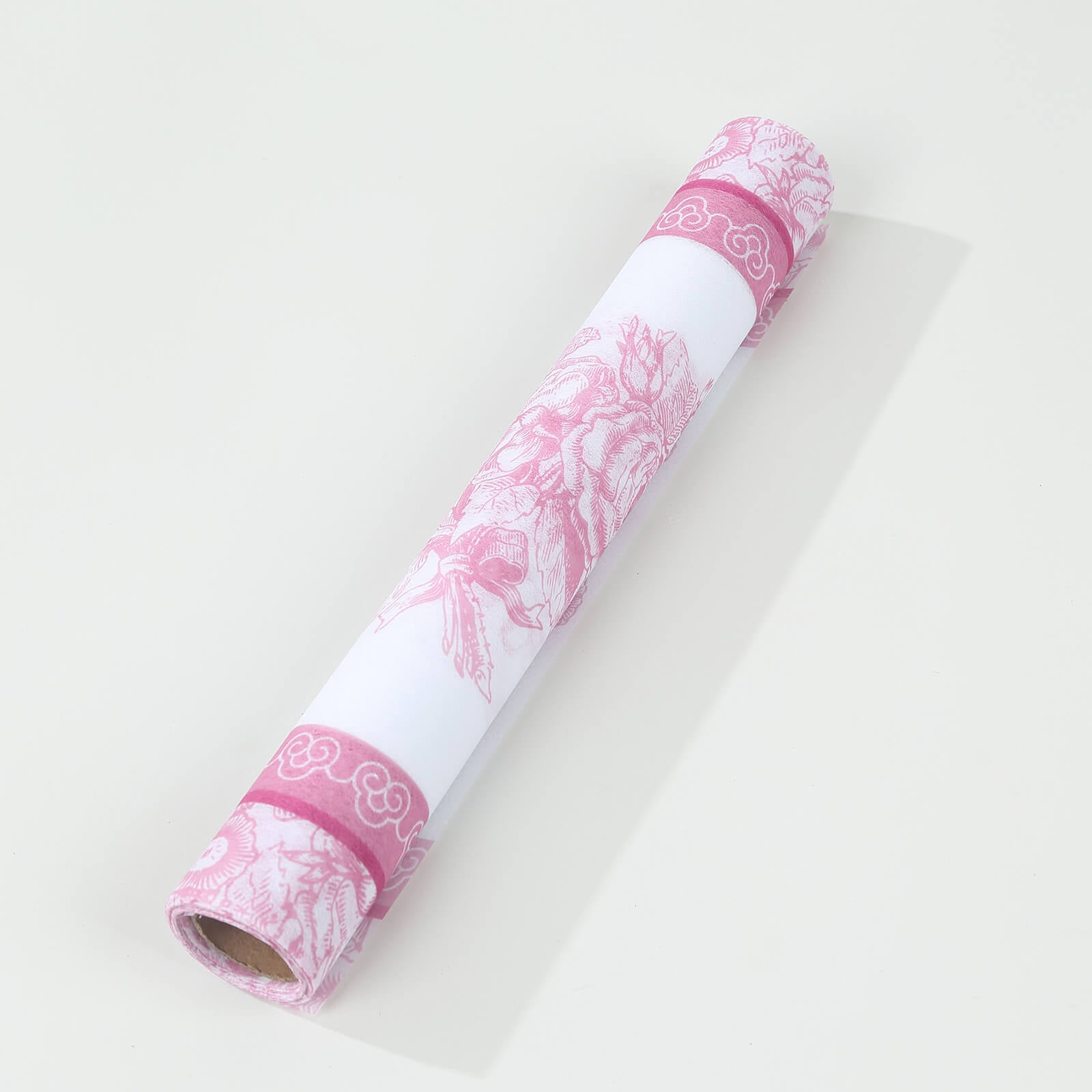 White with pink floral disposable table runner rolled up.