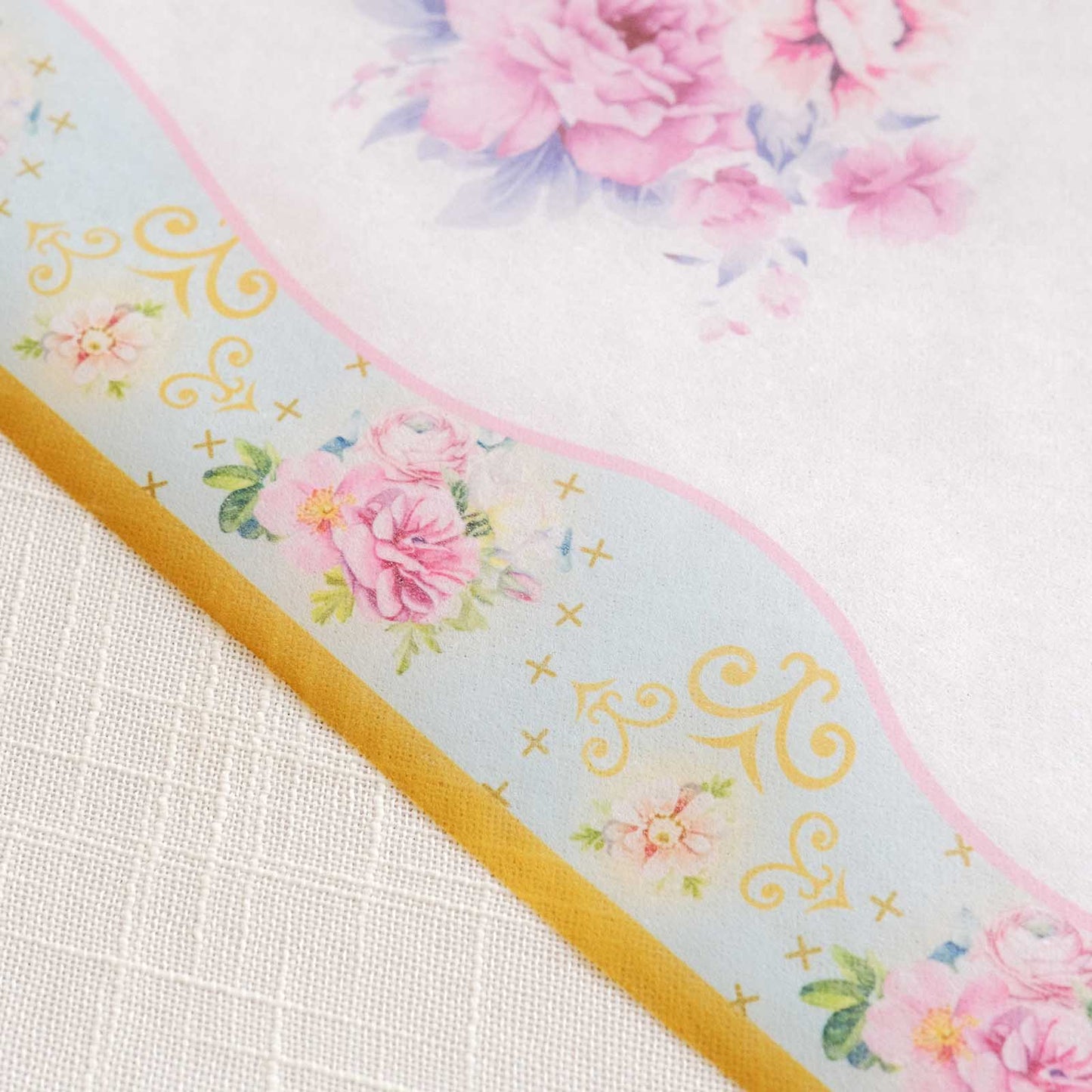 White disposable table runner with pink peony floral print.