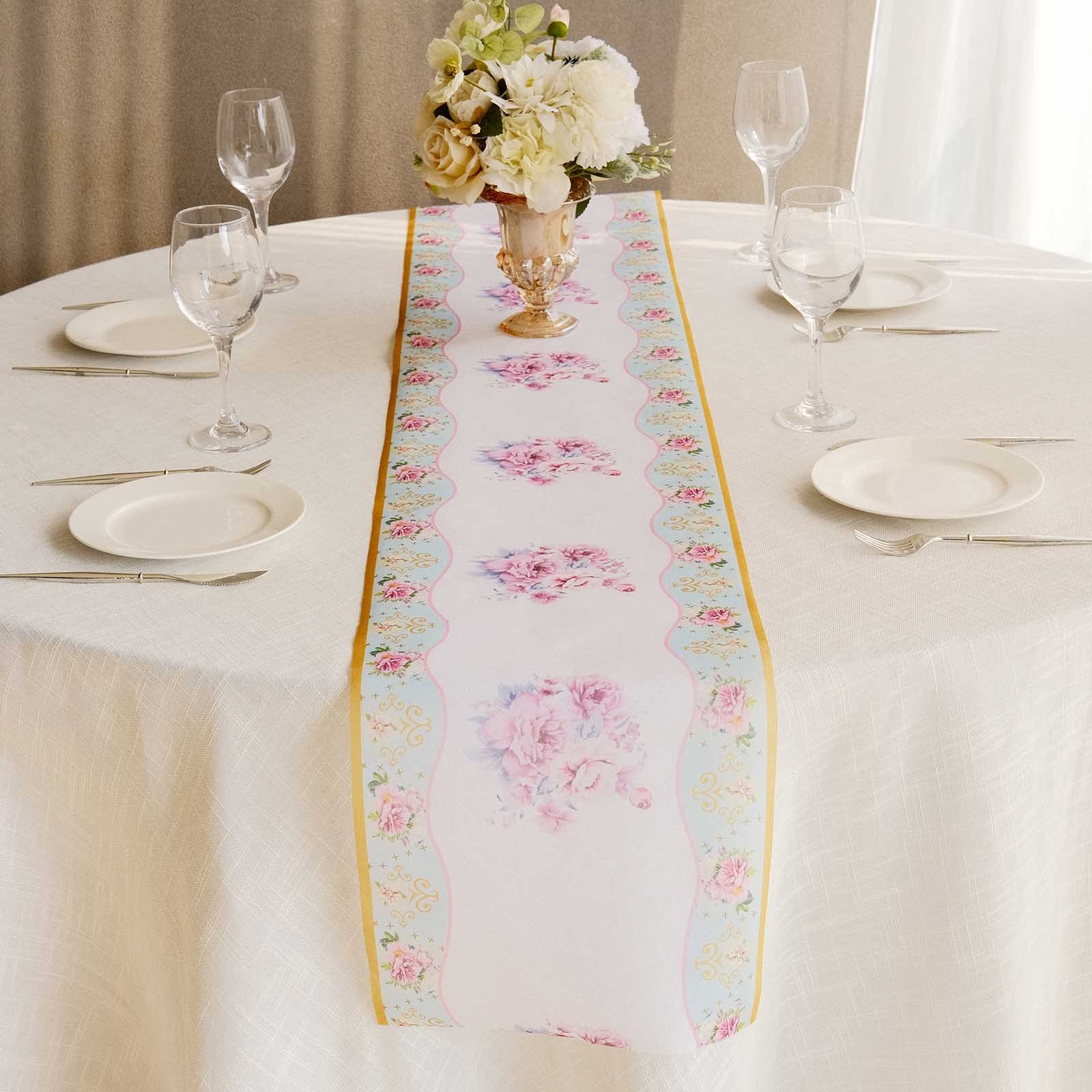 White table runner with pink peony floral print on a dining table setting.