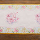 White disposable table runner with pink peony floral print.