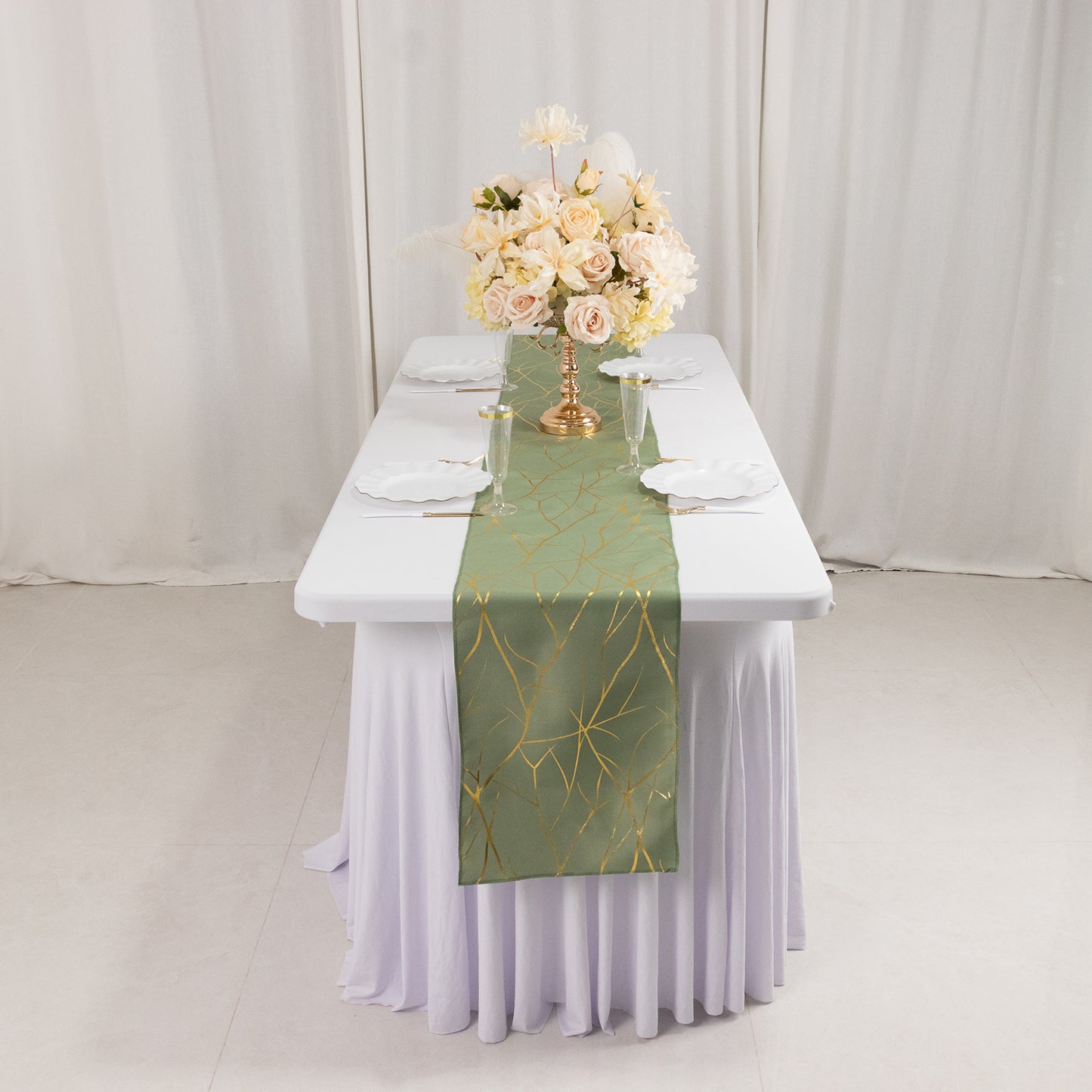 9ft dusty sage green table runner with gold foil tree branch pattern on a dining table.