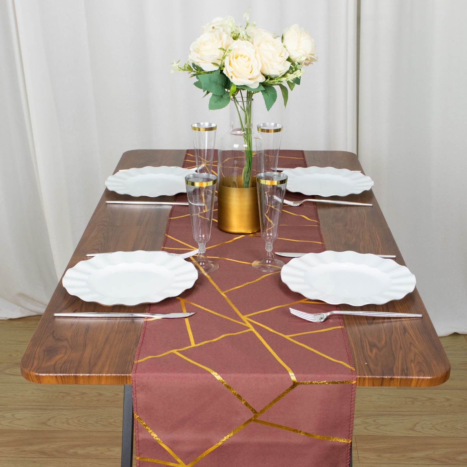 Cinnamon rose table runner with gold foil geometric pattern on a dining table.