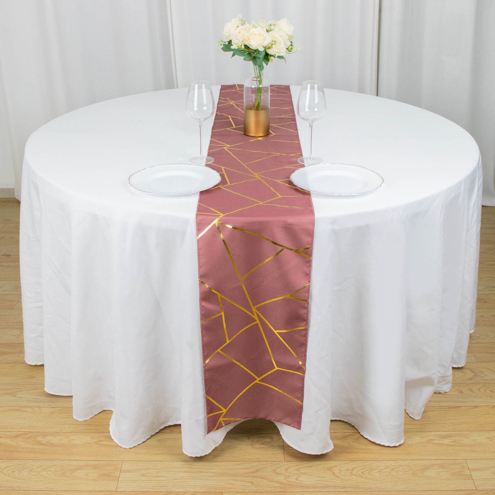Cinnamon rose table runner with gold foil geometric pattern on a round table.