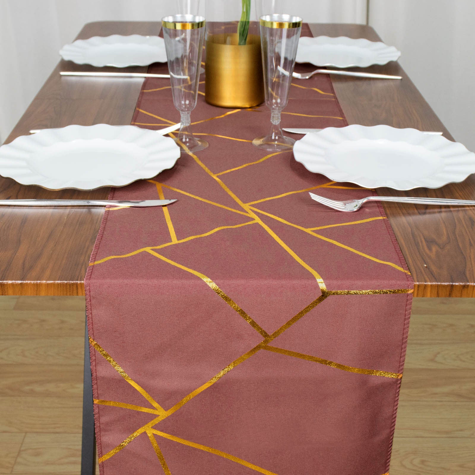 Cinnamon rose table runner with gold foil geometric pattern on a dining table.