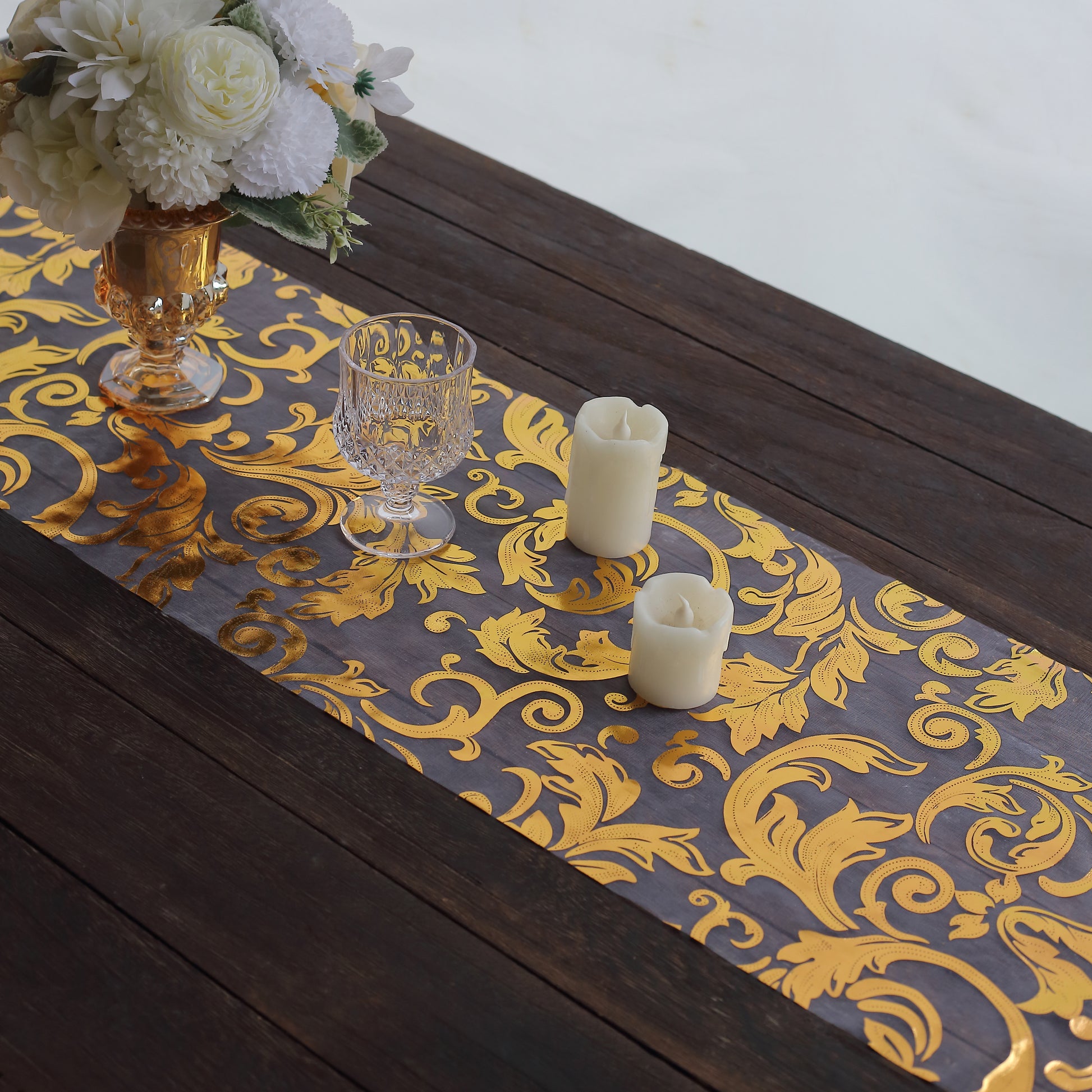 Metallic gold sheer organza table runner with swirl foil flower design.