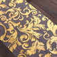 Metallic gold sheer organza table runner with swirl foil flower design.