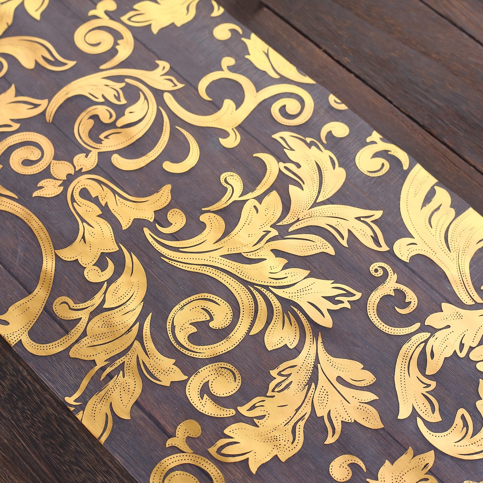 Metallic gold sheer organza table runner with swirl foil flower design.