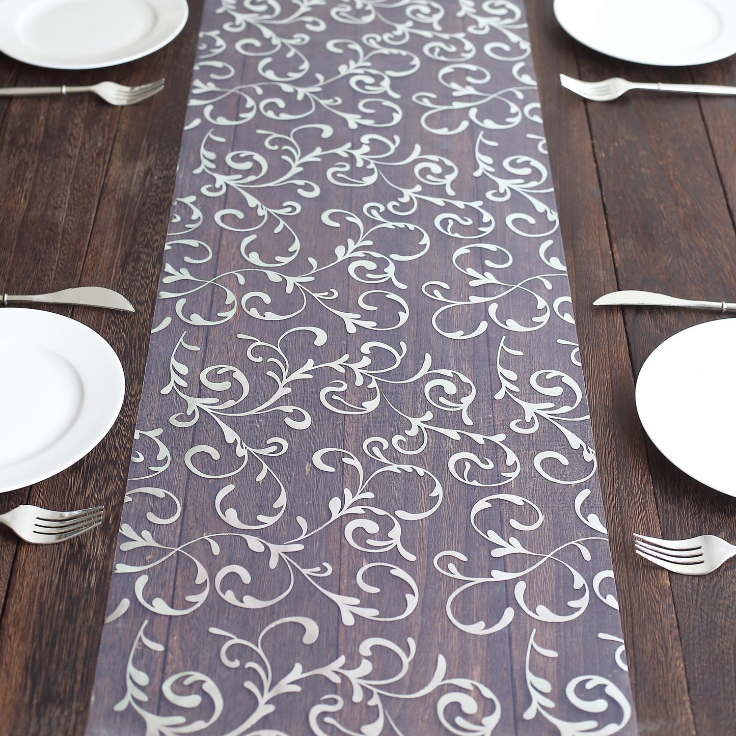 Metallic silver mesh table runner with embossed foil flower design.