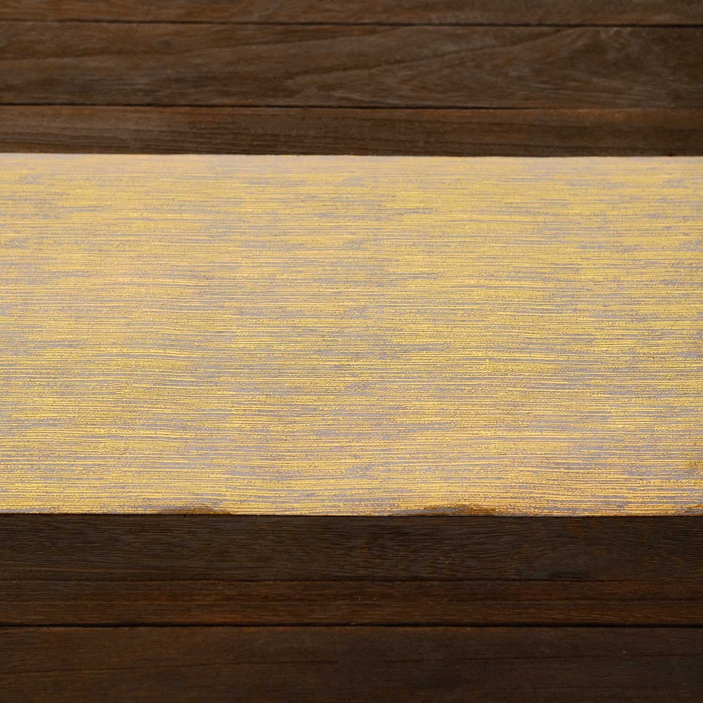Metallic gold faux suede table runner roll on a wooden surface.