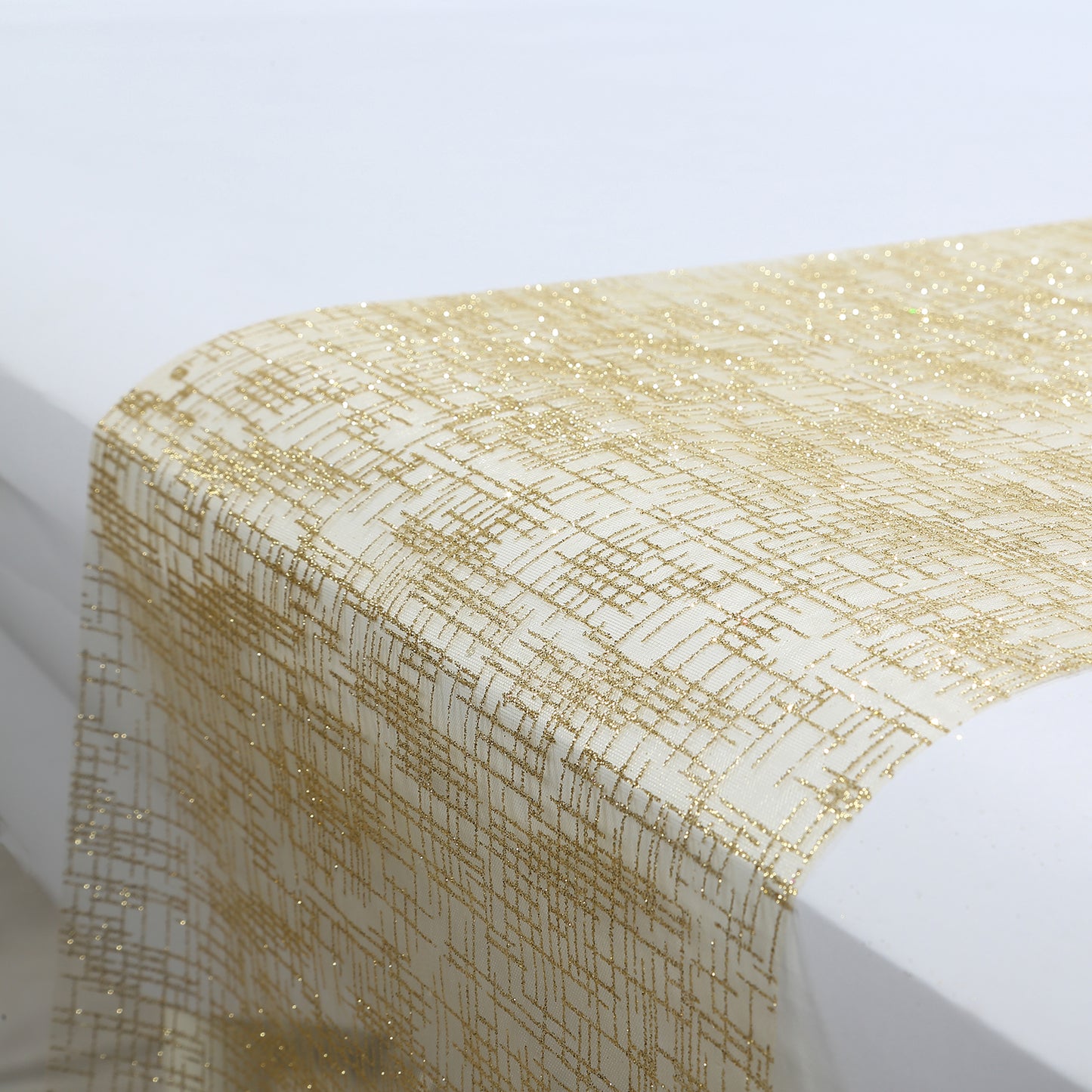 Metallic gold glitter mesh table runner on a white table.