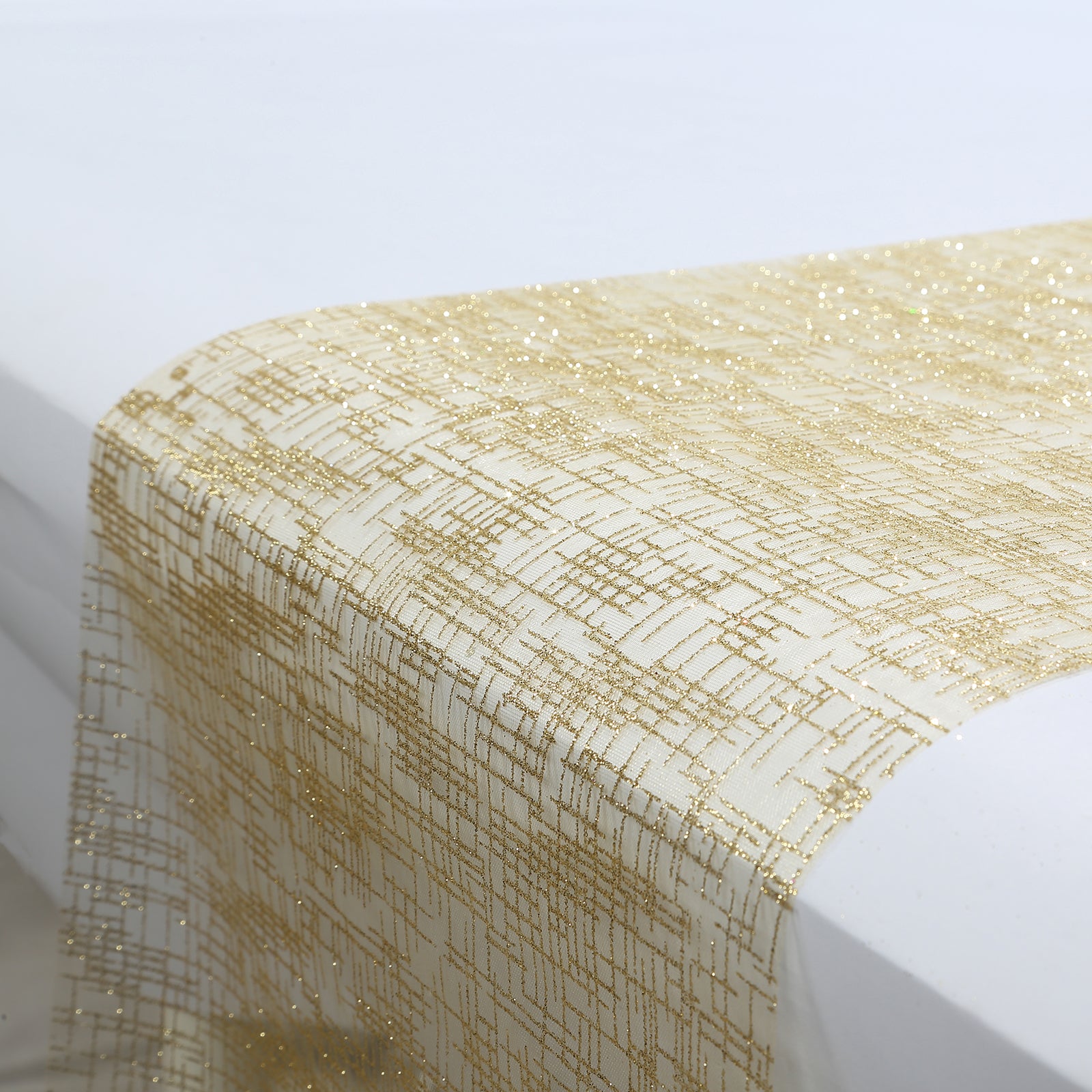 Metallic gold glitter mesh table runner on a white table.