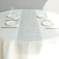 Metallic silver glitter disposable table runner on a round table setting.